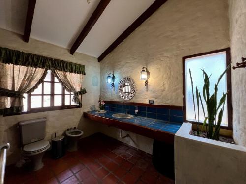 a bathroom with a toilet and a sink and a mirror at Rustic lodge Samaipata in Samaipata