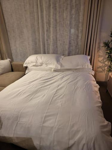 a white bed with white sheets and pillows at Entire Prestige Apartment in Poole Quay - Free Parking, Fast WiFi, Smart TV & Netflix in Poole