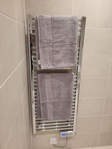 a towel rack in a bathroom with towels on it at Entire Prestige Apartment in Poole Quay - Free Parking, Fast WiFi, Smart TV & Netflix in Poole