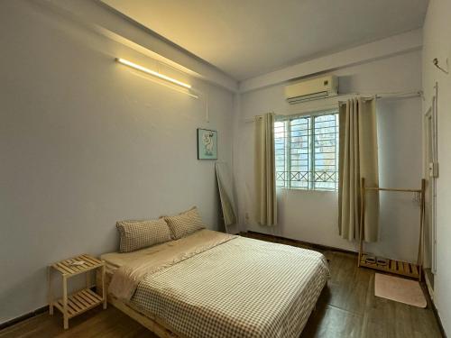 een kleine slaapkamer met een bed en een raam bij Paradiso in Ho Chi Minh-stad