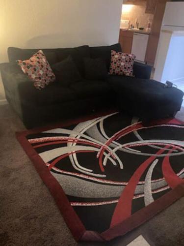 Sofá negro en una sala de estar con alfombra en A Classy Uneic Peace en Brook Park