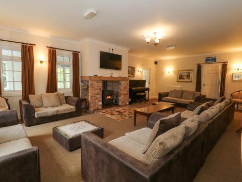 a large living room with couches and a fireplace at Rosehill Manor in Market Drayton