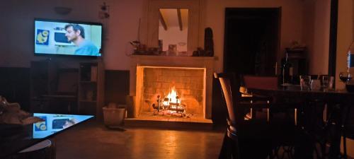 a fire in a fireplace in a living room with a tv at Domaine de La Sarrotte in Saugon
