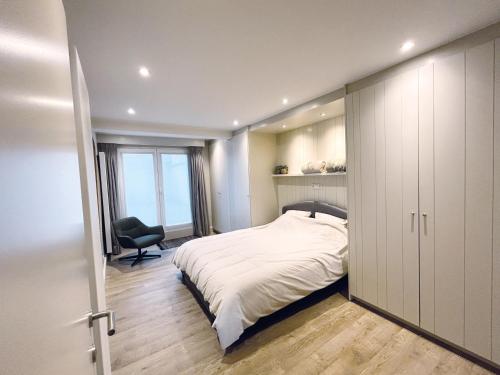 een slaapkamer met een bed en een stoel erin bij Eden-Beach in Oostende
