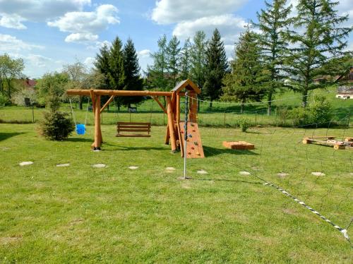 a playground with a swing set in a field at Domek u Gołąbków Bieszczady in Lesko