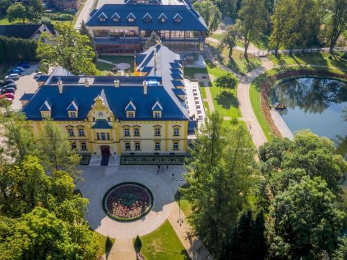 an aerial view of a large yellow building with a blue roof at Vila MAX - WHIRLPOOL & BAZÉN & SAUNA in Velké Losiny