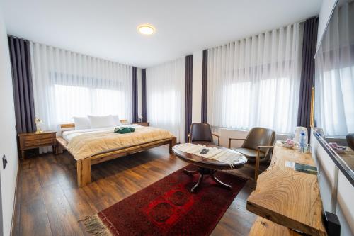 a bedroom with a bed and a table and chairs at Doa Boutique Hotel in Peje