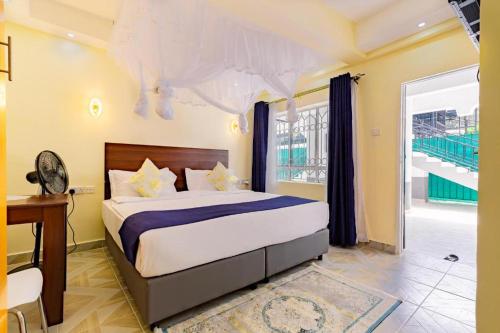 a bedroom with a bed and a desk and a window at Markson Hotel Kilimani in Nairobi