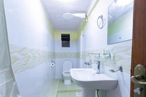a bathroom with a sink and a toilet at Markson Hotel Kilimani in Nairobi