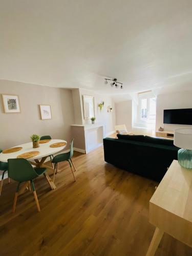 un salon avec une table, des chaises et un canapé dans l'établissement Au cœur de Blois, à Blois