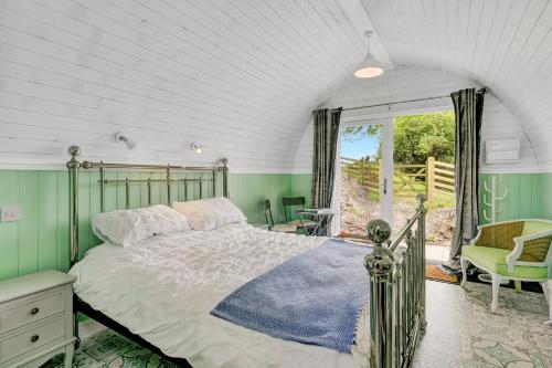 a bedroom with a bed and a window at Little House in the Big Woods Brendon Hill in Watchet