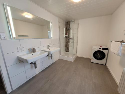 a white bathroom with two sinks and a shower at Berghof Wörner 2 Wohnungen für bis zu 20 Personen mit Balkon I Terrasse I 4 Bäder I NETFLIX I Ruhig und gemütlich wohnen in Villingen-Schwenningen