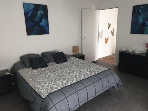 una camera da letto con un grande letto con cuscini neri di Gardenia a Villenauxe-la-Grande