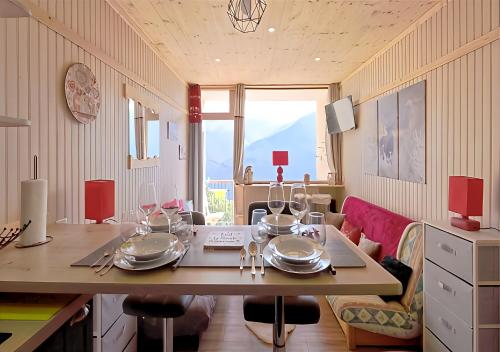 une salle à manger avec une table et de la vaisselle dans l'établissement Le Panorama D'Orcières, à Orcières