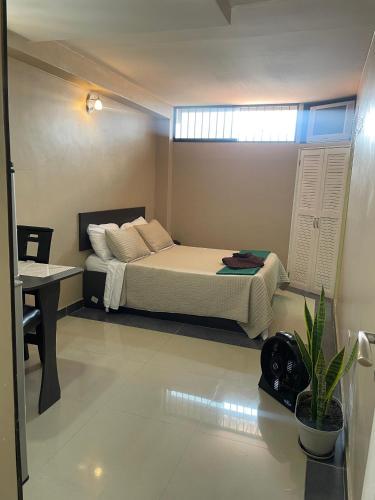 1 dormitorio con cama, escritorio y ventana en Apartamento tipo estudio, en Mérida