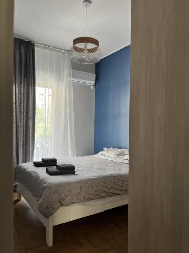 sypialnia z łóżkiem z niebieską ścianą i oknem w obiekcie Deseo 2 Apartments w Atenach