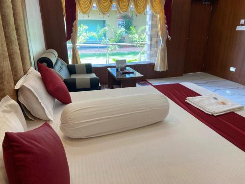 Cette chambre d'hôtel comprend deux lits avec un fauteuil pouf. dans l'établissement Saikat Saranya Resort, Mandarmoni Beach, à Mandarmoni