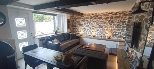 sala de estar con sofá y mesa en calm stone house elemm, en Kastoria