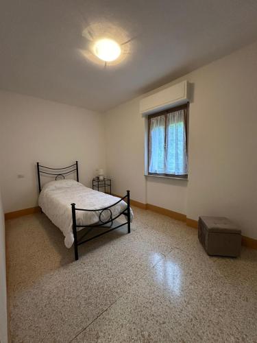 un dormitorio vacío con una cama y una ventana en Casa Vacanze ''La Torre'' en Cascia