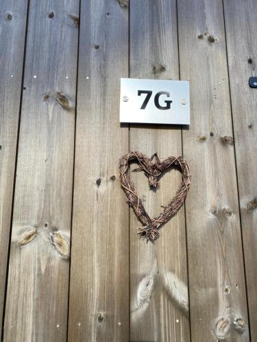 a sign with a heart on a wooden fence at Paradis på Sørlandet in Kristiansand