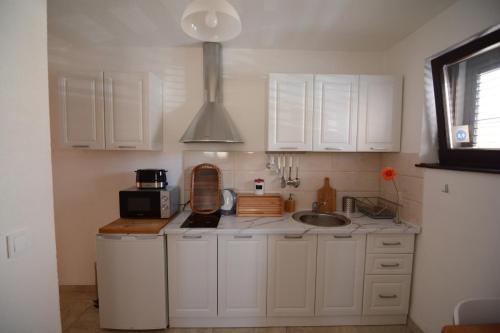 a kitchen with white cabinets and a sink at Apartment Bojadzi in Ohrid