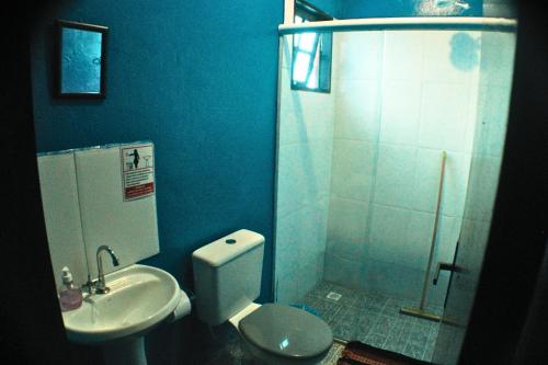 a bathroom with a toilet and a sink and a shower at Tahoma Chalé Rustico Lila Prumirim in Ubatuba