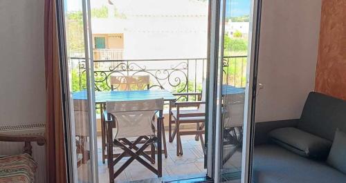 a room with a table and chairs on a balcony at Kostantina's House Kythera in Kámbos