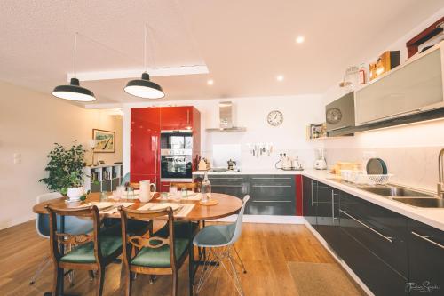 Il comprend une cuisine avec une table et des chaises en bois. dans l'établissement Superbe appartement, 1min du tramway, parking, A/C, à Blagnac