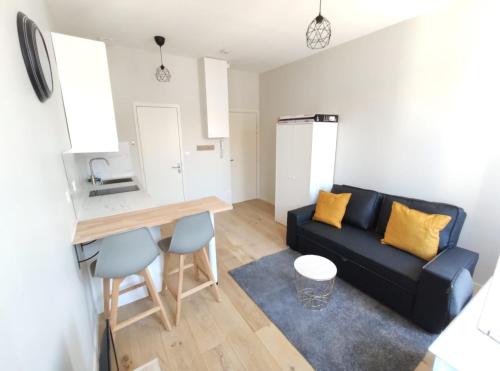 un salon avec un canapé noir et une table dans l'établissement Le Petit Robert - Centre - Calme, à Toulouse