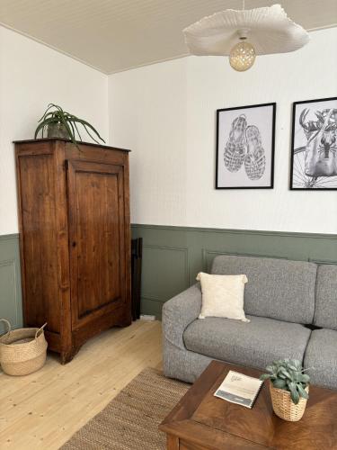 a living room with a couch and a table at Gustave charmant appartement en cœur de ville à 20 mètres de la mer in Les Sables-dʼOlonne