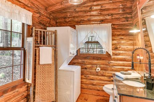 uma casa de banho com paredes de madeira, um WC e um lavatório. em Serene Lake Luzerne Cabin with Lake and Beach Access! em Lake Luzerne