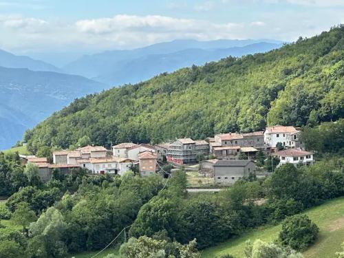 a group of houses on a hill with trees at Casa del Giglio a Cadelmonte in Valle