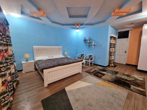 ein Schlafzimmer mit einem Bett und einer blauen Wand in der Unterkunft Salsa Resort 