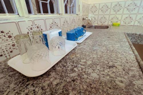 a kitchen counter with several glass containers on it at Avanti ONE 2BHK 3KM from Mahakal in Ujjain