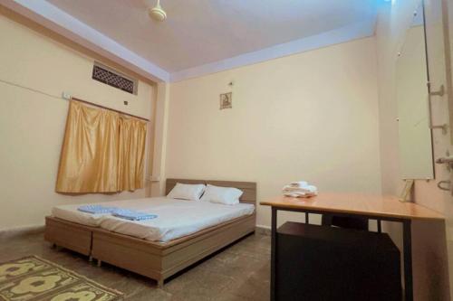 a bedroom with a bed and a desk in it at Avanti ONE 2BHK 3KM from Mahakal in Ujjain