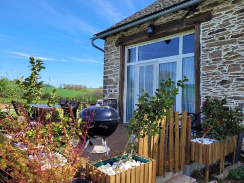 a garden with a large window and a grill at Tout au bout du chemin in Réquista