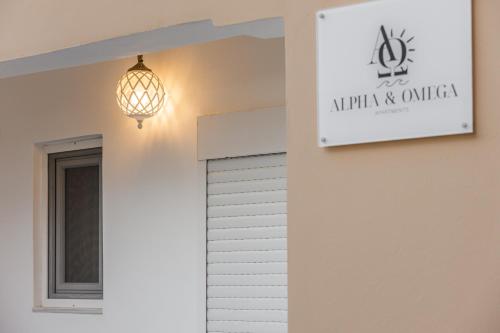 a sign on the side of a building with a light at Alpha & Omega Apartments in Karpathos Town