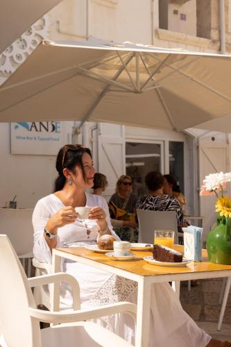 a woman sitting at a table eating a piece of cake at Dimore di Brando Vico Gelso in Polignano a Mare