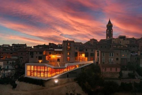 un edificio con una torre dell'orologio in una città al tramonto di Casa Carraia a Peccioli