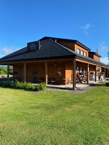 a large building with a grass field in front of it at Suites sur Lac Superieur-Mont-Tremblant in Lac-Superieur