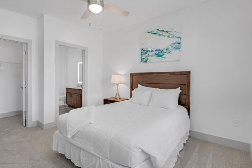 um quarto branco com uma cama e uma ventoinha de tecto em Modern Luxury In The Heart Of Knoxville em Knoxville