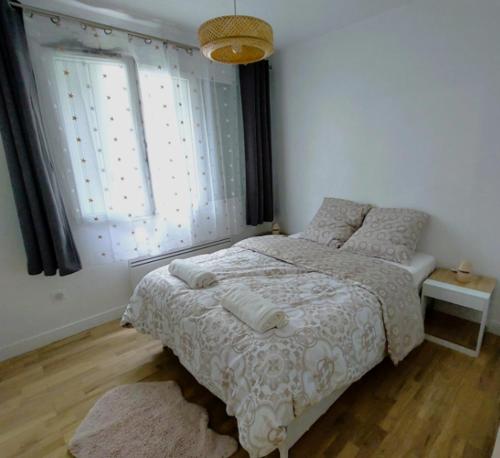een slaapkamer met een bed en een raam bij Cosy Flat - Stade de France in Saint-Denis