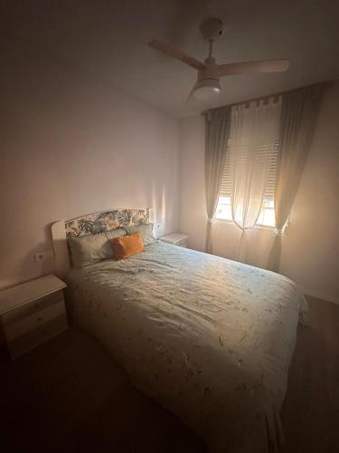 a bedroom with a bed and a ceiling fan at Apartamento Tavernes Playa in Tavernes de Valldigna