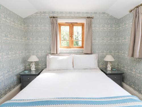 キャッスルトンにあるBee Garthのベッドルーム1室(青と白の壁紙のベッド1台付)
