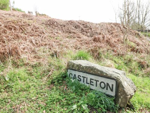 a sign sitting on the side of a hill at Bee Garth in Castleton