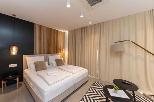 ein Schlafzimmer mit einem großen weißen Bett und einem Tisch in der Unterkunft White Rooms by Belmont Realty in Zadar