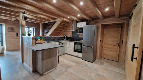 a large kitchen with wooden walls and a wooden ceiling at La ferme de Jouane in Besse-et-Saint-Anastaise