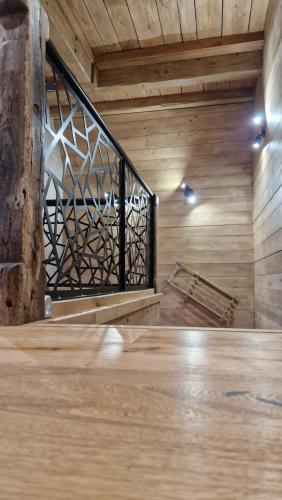 an empty room with a wooden floor and a staircase at La ferme de Jouane in Besse-et-Saint-Anastaise