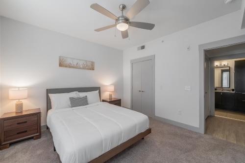 1 dormitorio con cama blanca y ventilador de techo en High End Apartment, Pool, Gym, Parking Cs, en Dallas