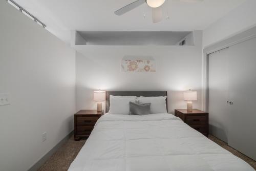 1 dormitorio blanco con 1 cama grande y 2 lámparas en Stunning 1 Bedroom Condo , Pool, Gym, Parking, Cs, en Dallas